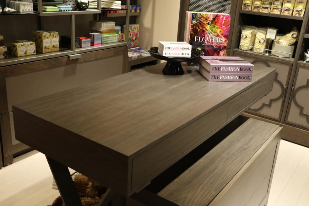 Large books on wood table with custom perimeter display in background