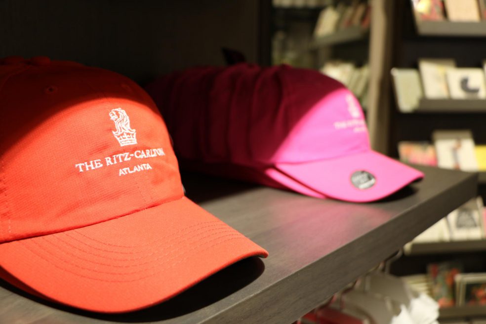 Hats with Ritz Carlton logo on wood retail shelving by Morgan Li