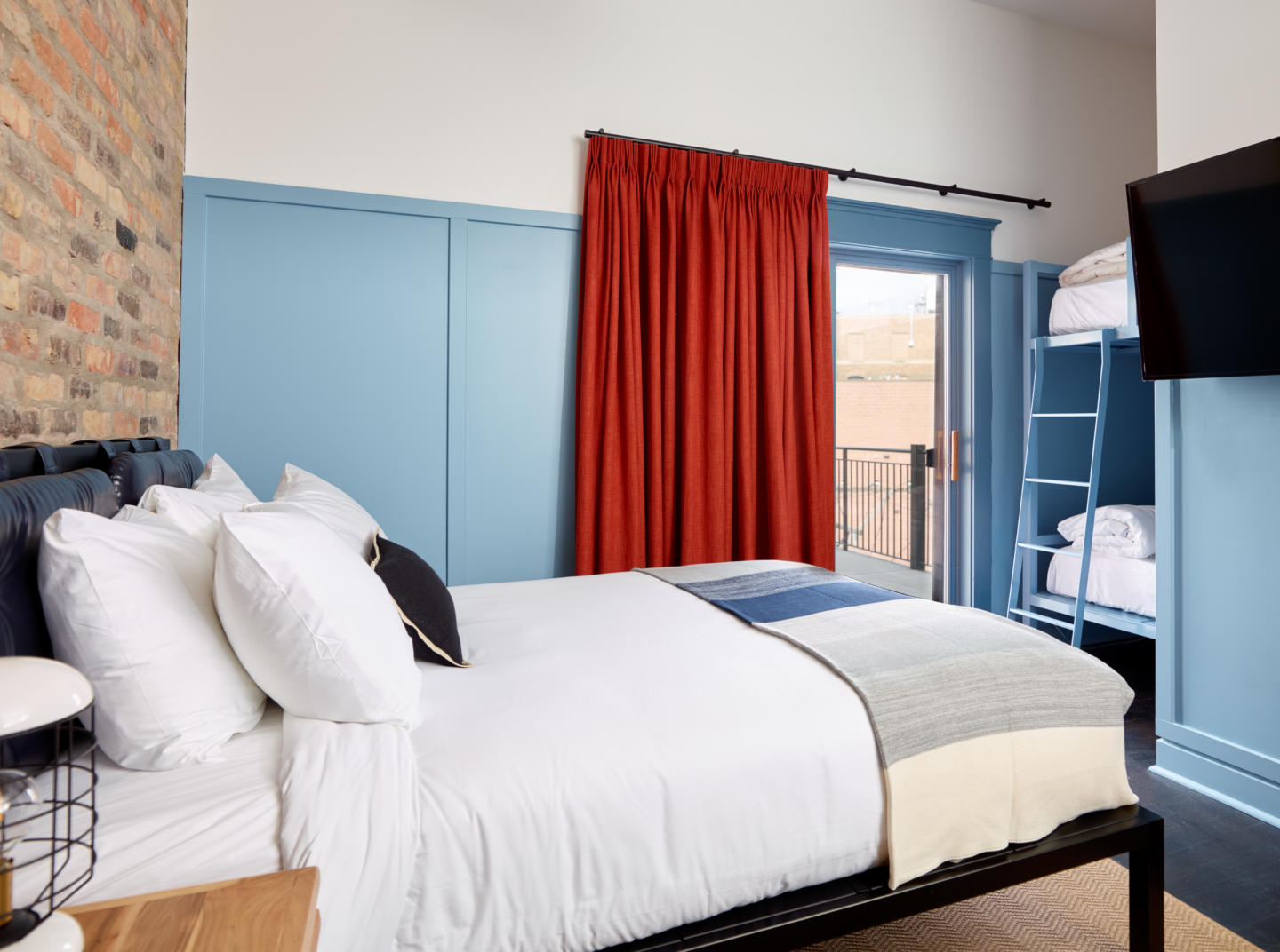 Guest suite at boutique hotel with bed, furniture, and bunk beds made by Morgan Li 