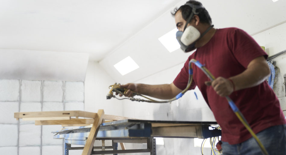 Wood fabrication company Morgan Li employee applies finish to retail display