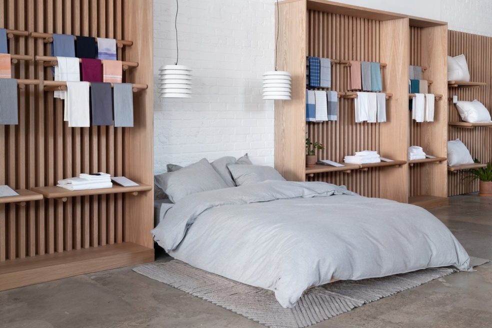 Wood floor displays and bed at Brooklinen flagship by Morgan Li