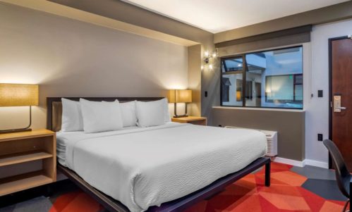 Metal bed frame and wood casegoods in Infinity Hotel guestroom by Morgan Li